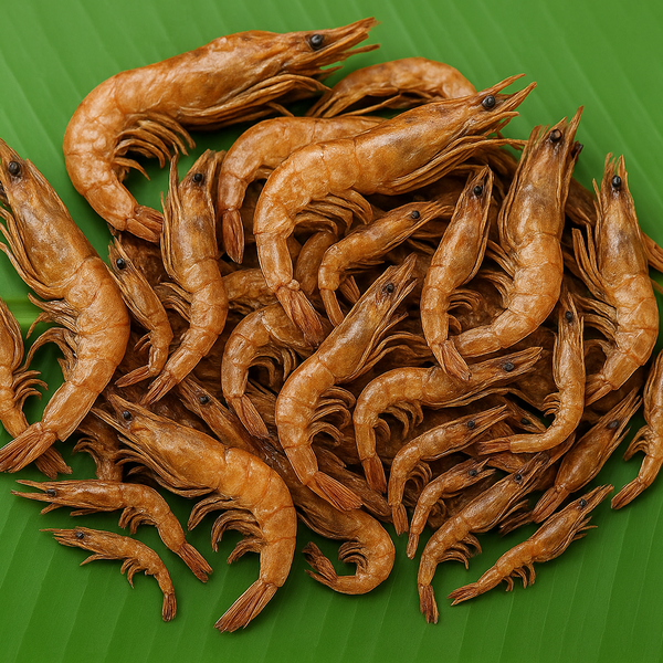 Professional product image of mixed-size brown dried prawns on banana leaf