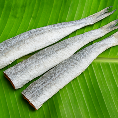 Square format headless dried fish on banana leaf